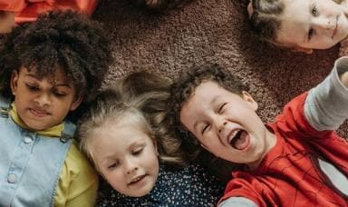 Selfie van blije kinderen op de vloer van de kinderopvang